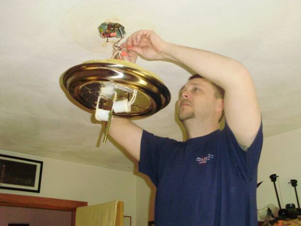 A licensed electrician installing a light.